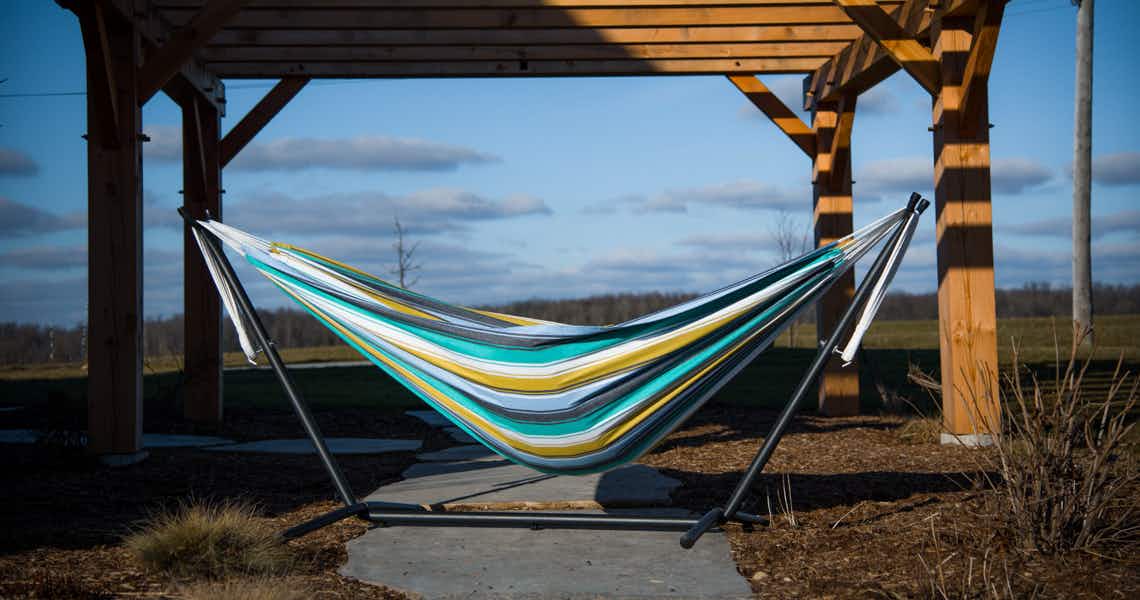 stock photo of vivere double hammock with stand with wood archway in background