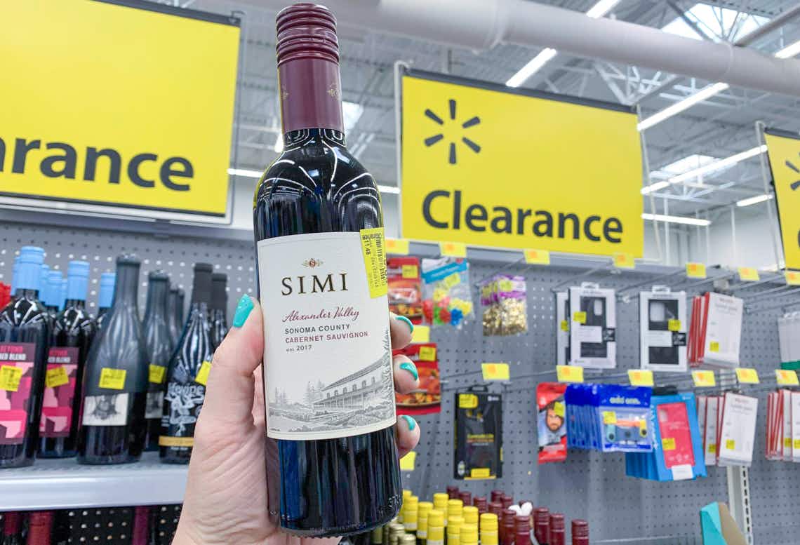 simi red wine mini bottle held in front of walmart clearance sign with clearance tag on side of bottle