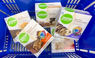 five boxes of zone perfect bars in a blue walmart hand basket