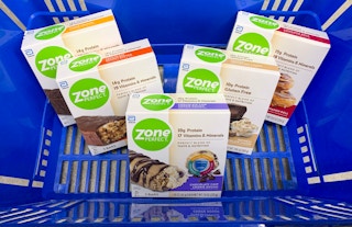 five boxes of zone perfect bars in a blue walmart hand basket