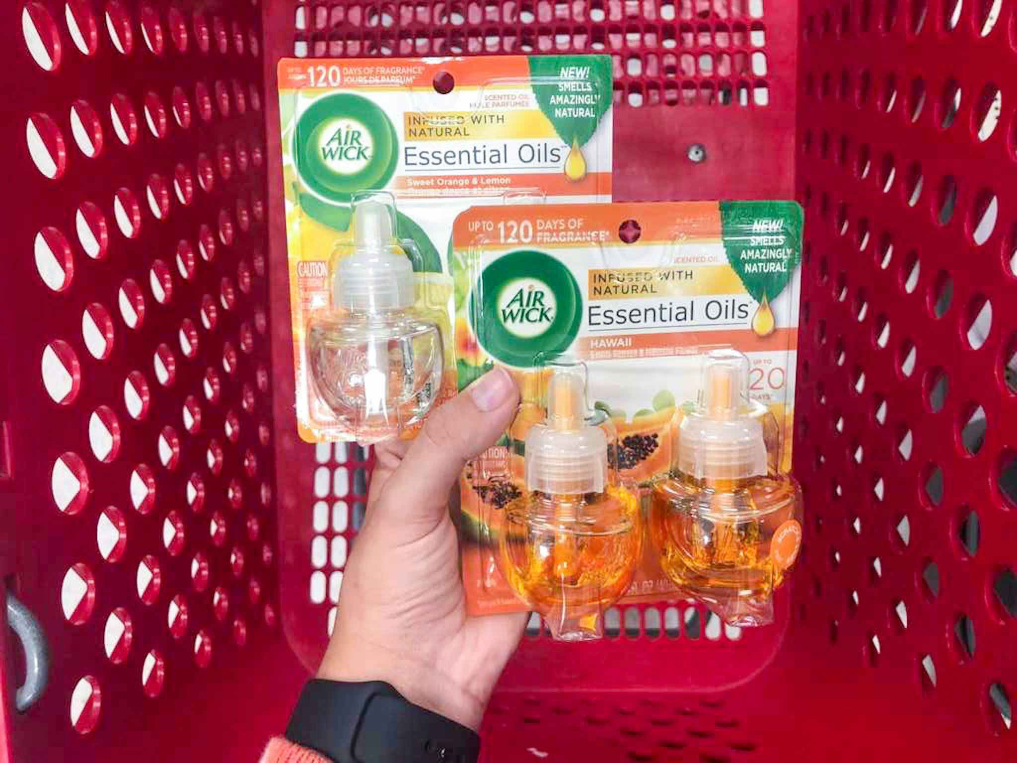 hand holding 2 packs of air wick scented oil refills at target