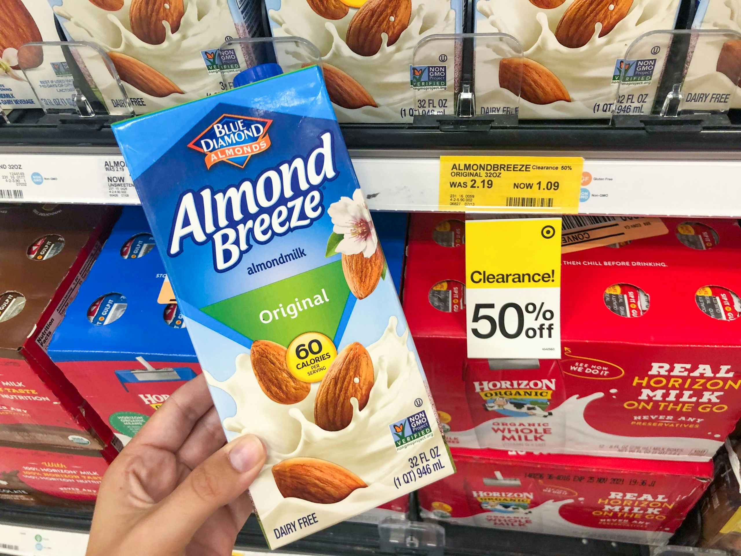 hand holding almond milk in front of clearance tag at Target