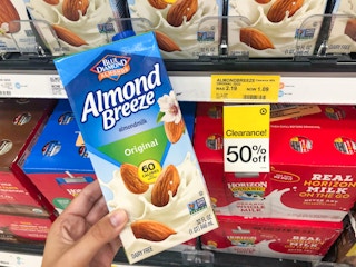 hand holding almond milk in front of clearance tag at Target