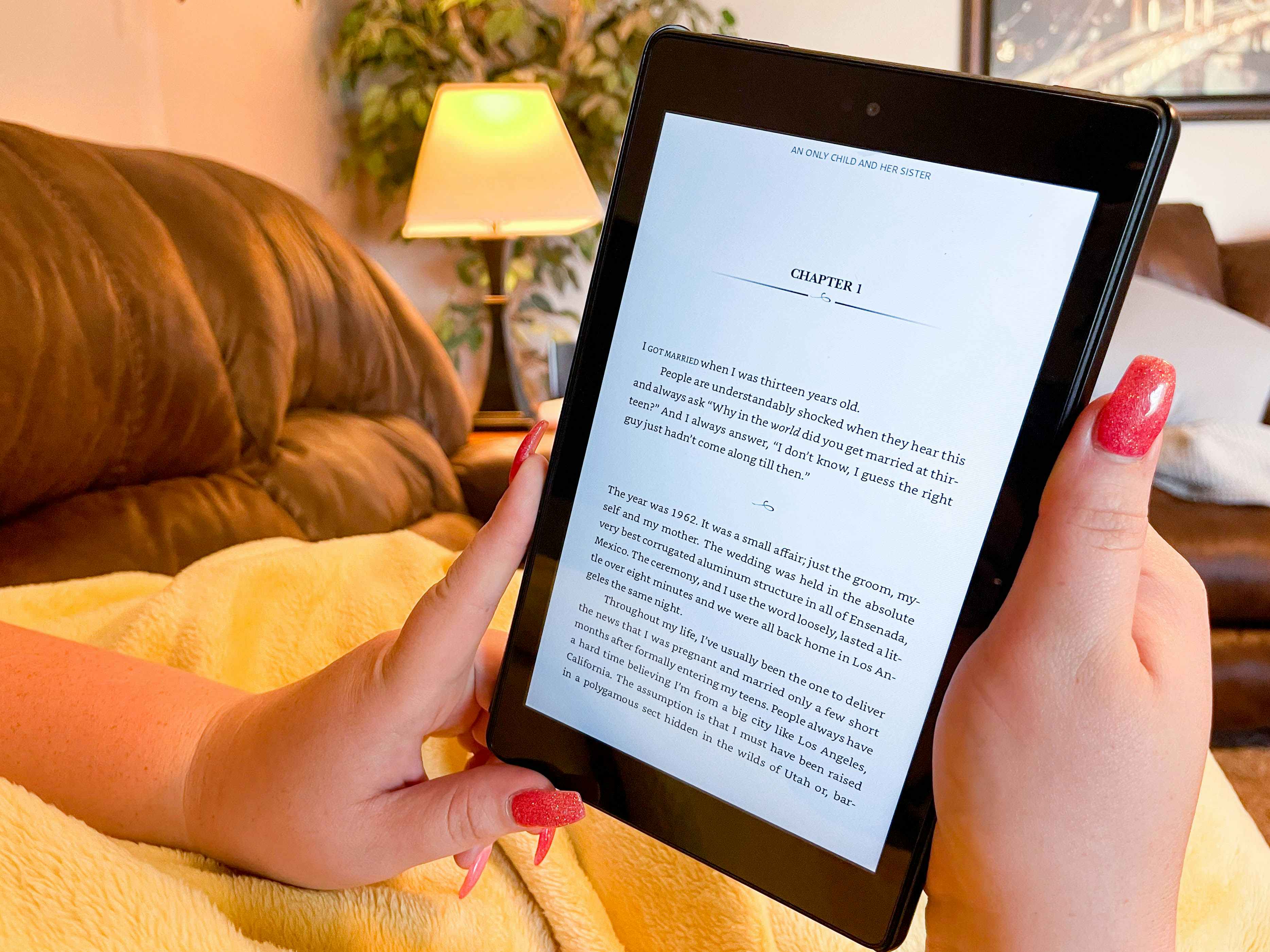 close up of a woman's hands holding a kindle reading