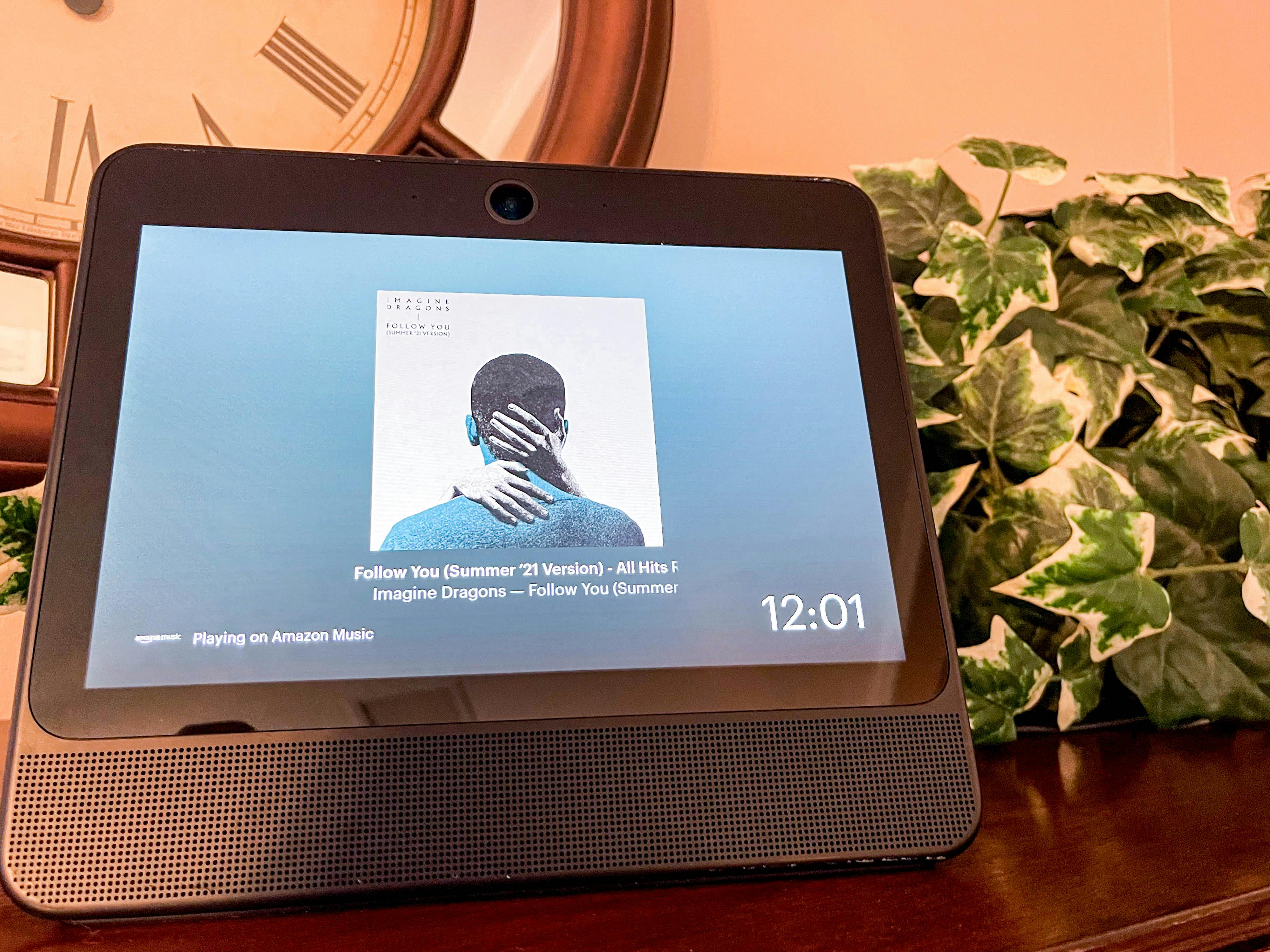 A Facebook portal displaying Amazon Music, sitting on a dresser.