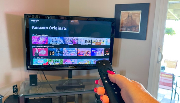woman holding amazon fire remote looking at tv