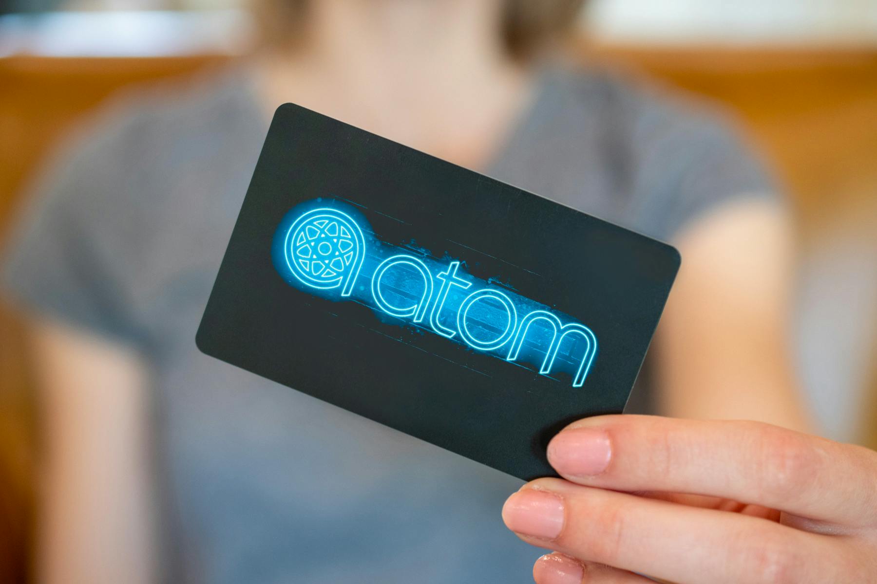 Woman holding an Atom Tickets gift card