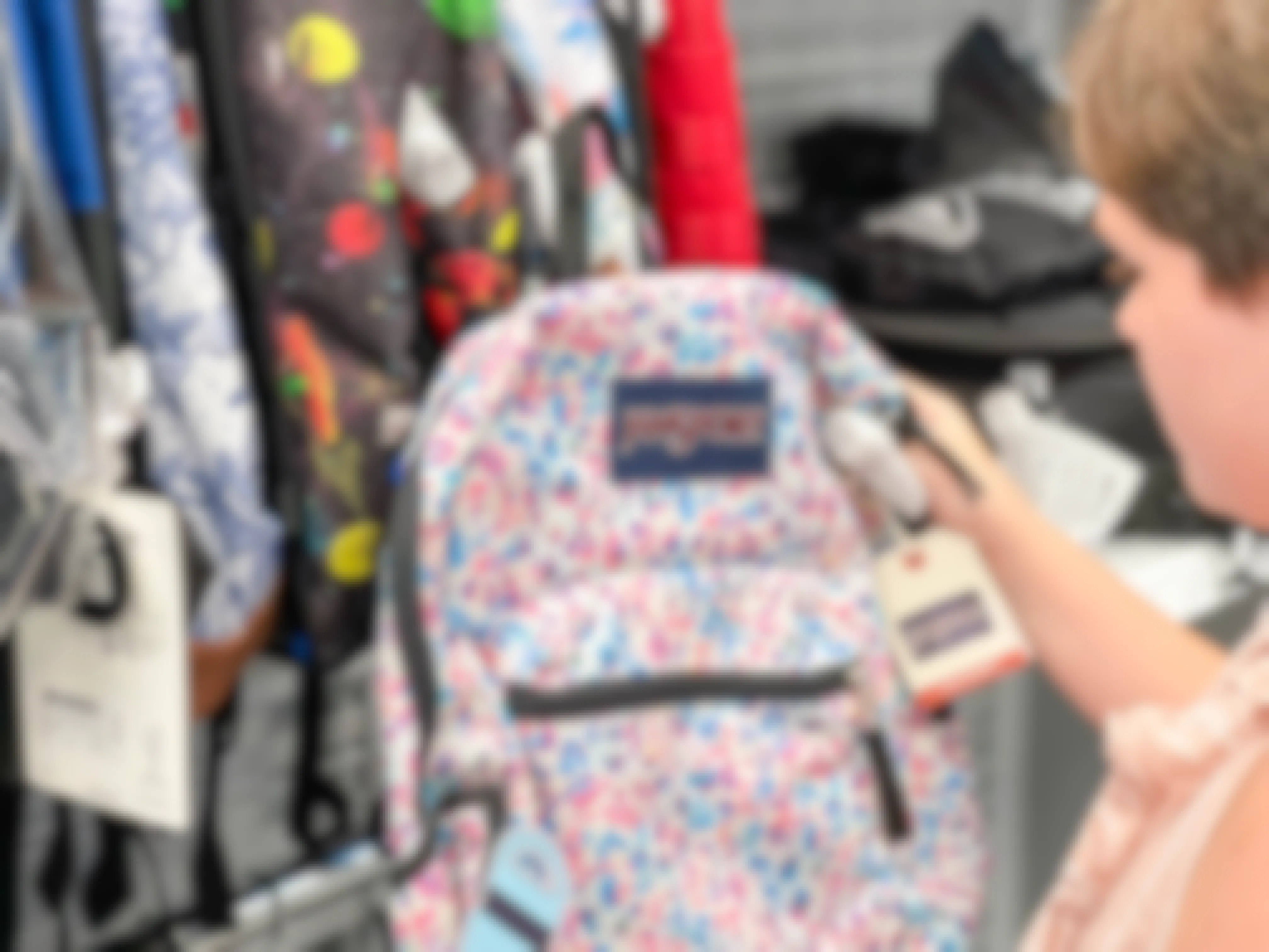 child looking at jansport backpack in store