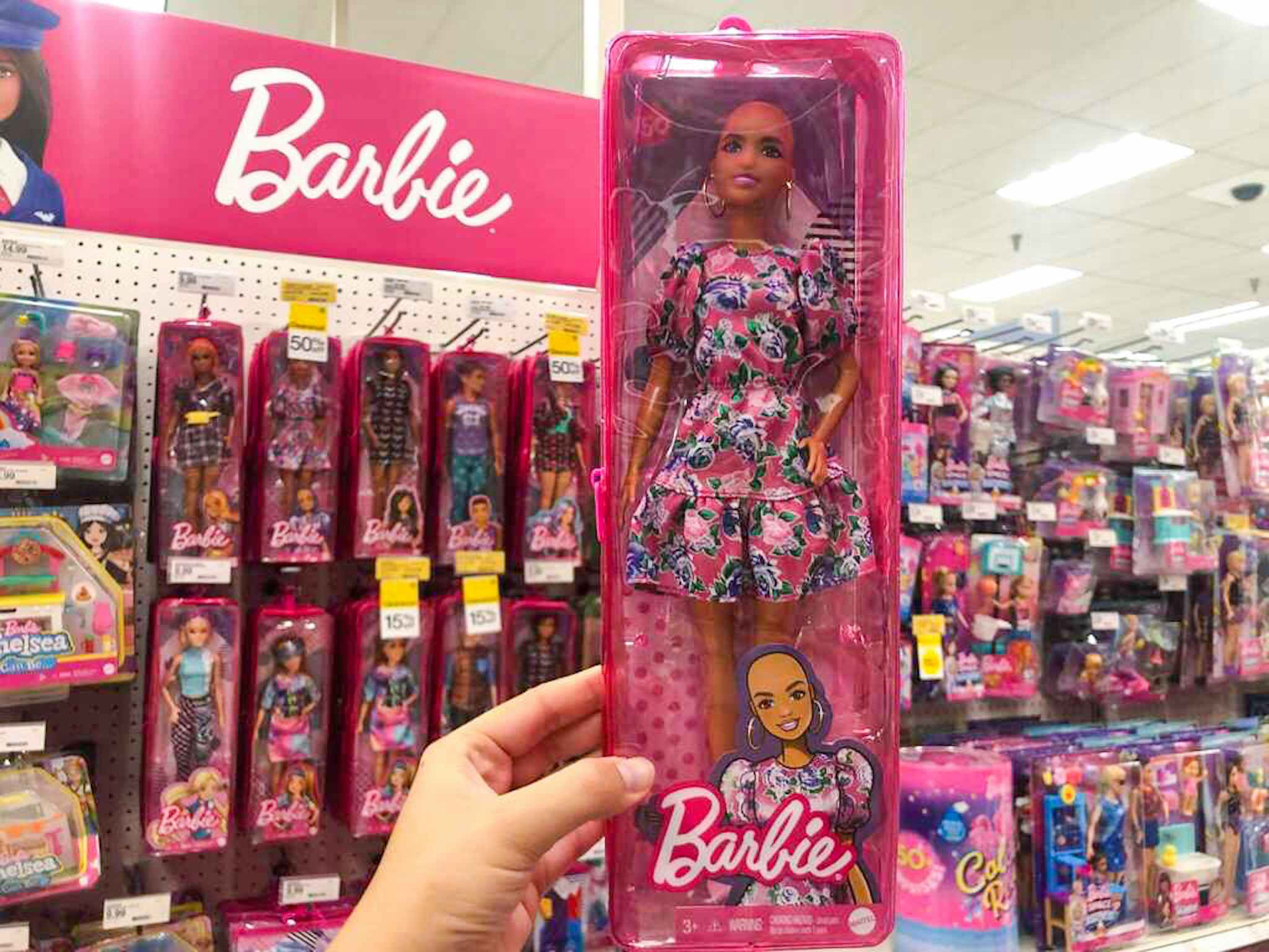 hand holding a barbie doll at target