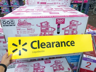 hand holding clearance sign in front of Barbie Dreamhouse