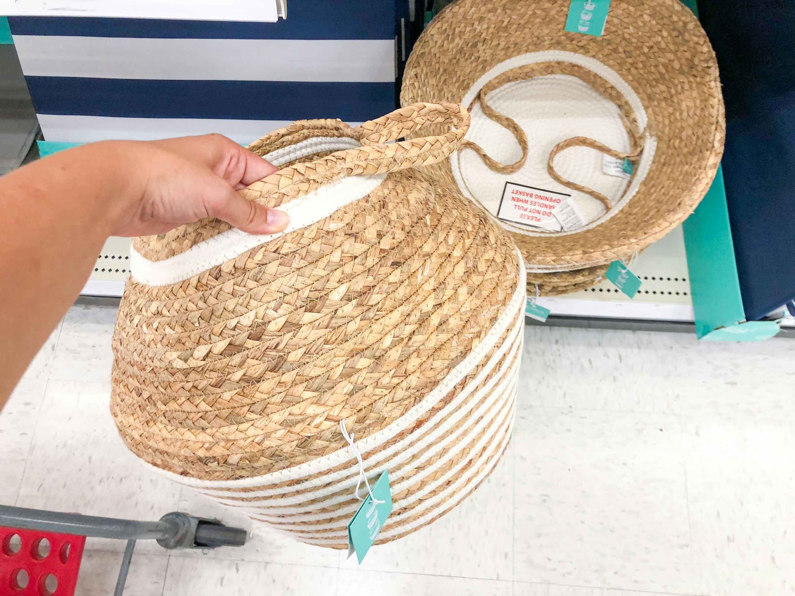 hand holding basket in store aisle