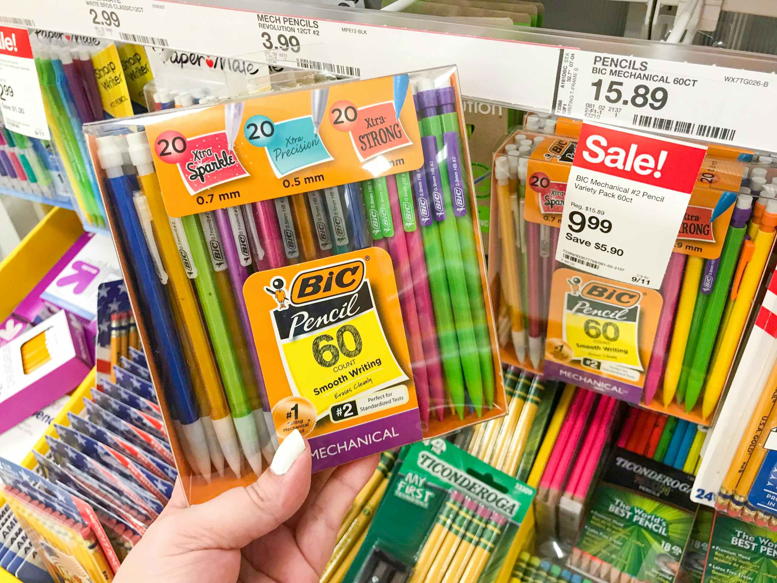 hand holding 60-pack of BIC mechanical pencils in front of store sale sign