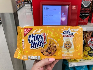 hand holding chips ahoy! golden chip cookies in front of price checker at target