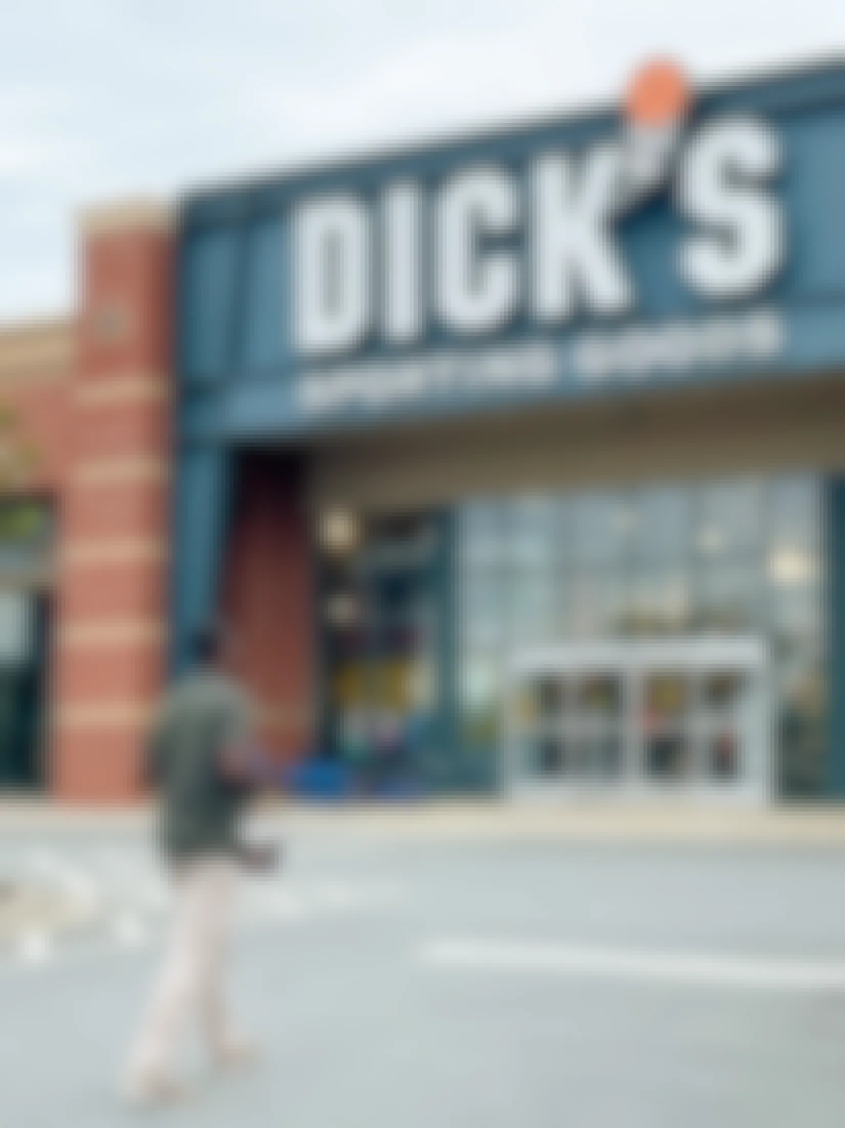 a man walking into dicks sporting goods with items in hand