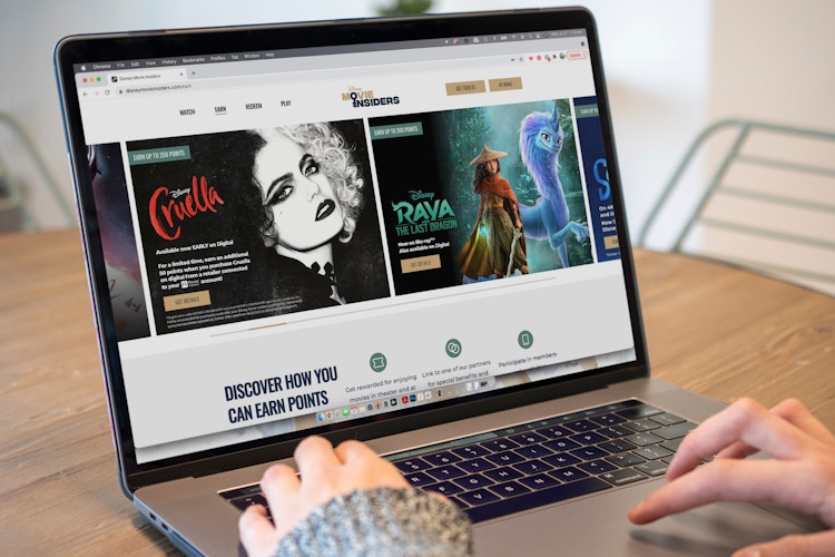 A person on a laptop viewing the Disney movie insider website