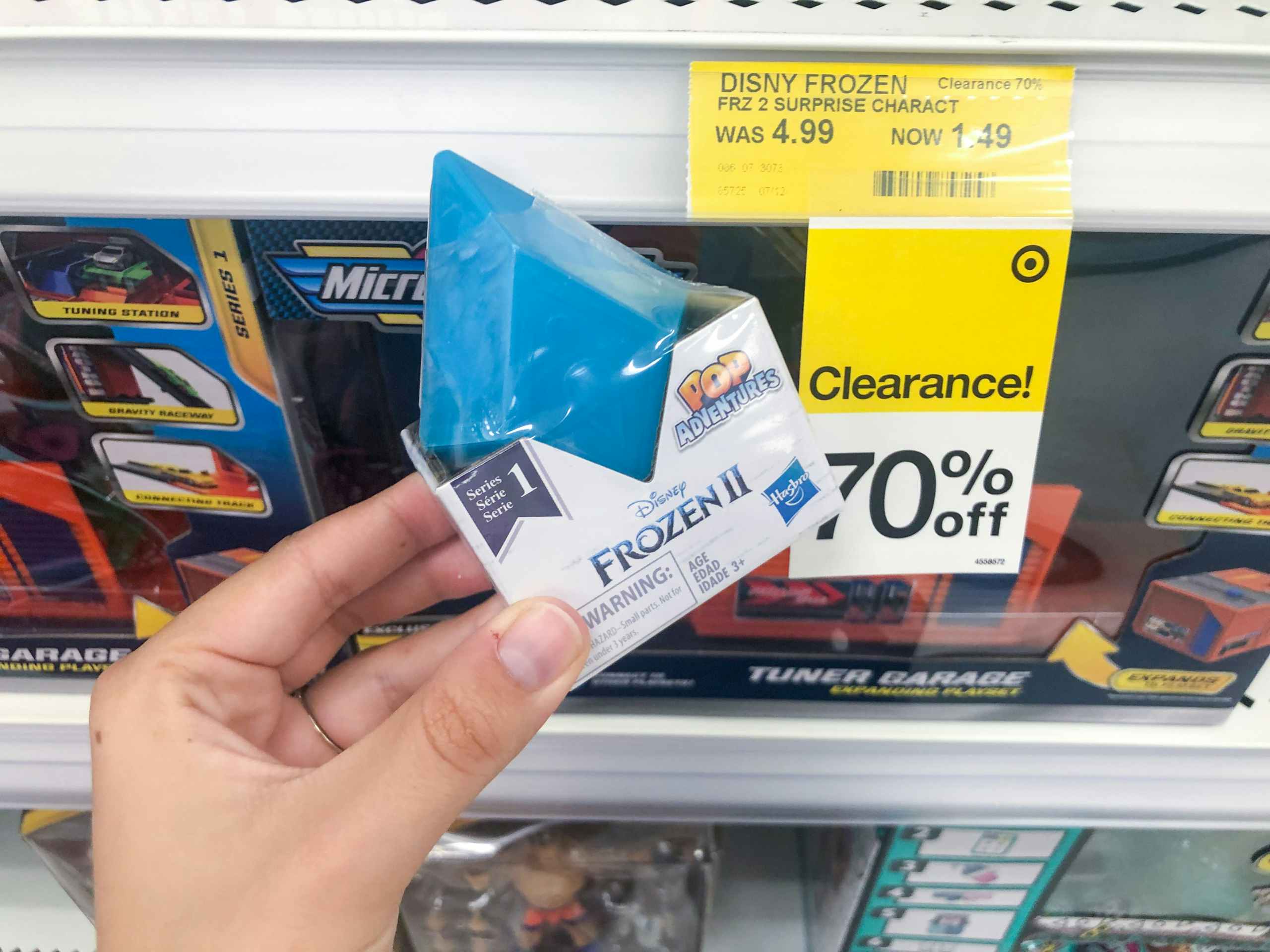 hand holding Disney toy in front of Target clearance sticker
