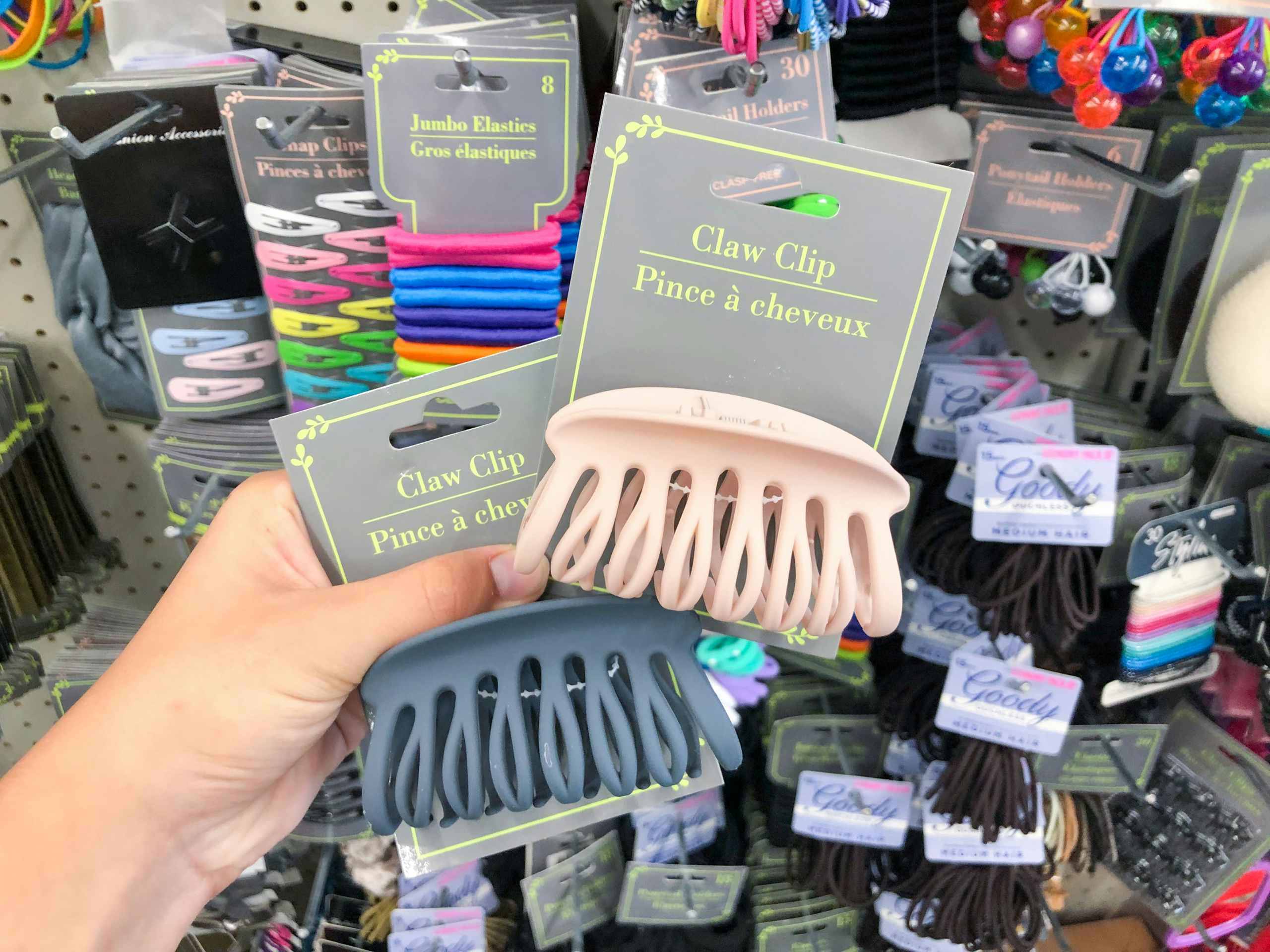 hand holding two packs of hair claw clips inside Dollar Tree