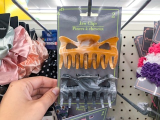 hand holding one two-pack of hair claw clips inside Dollar Tree