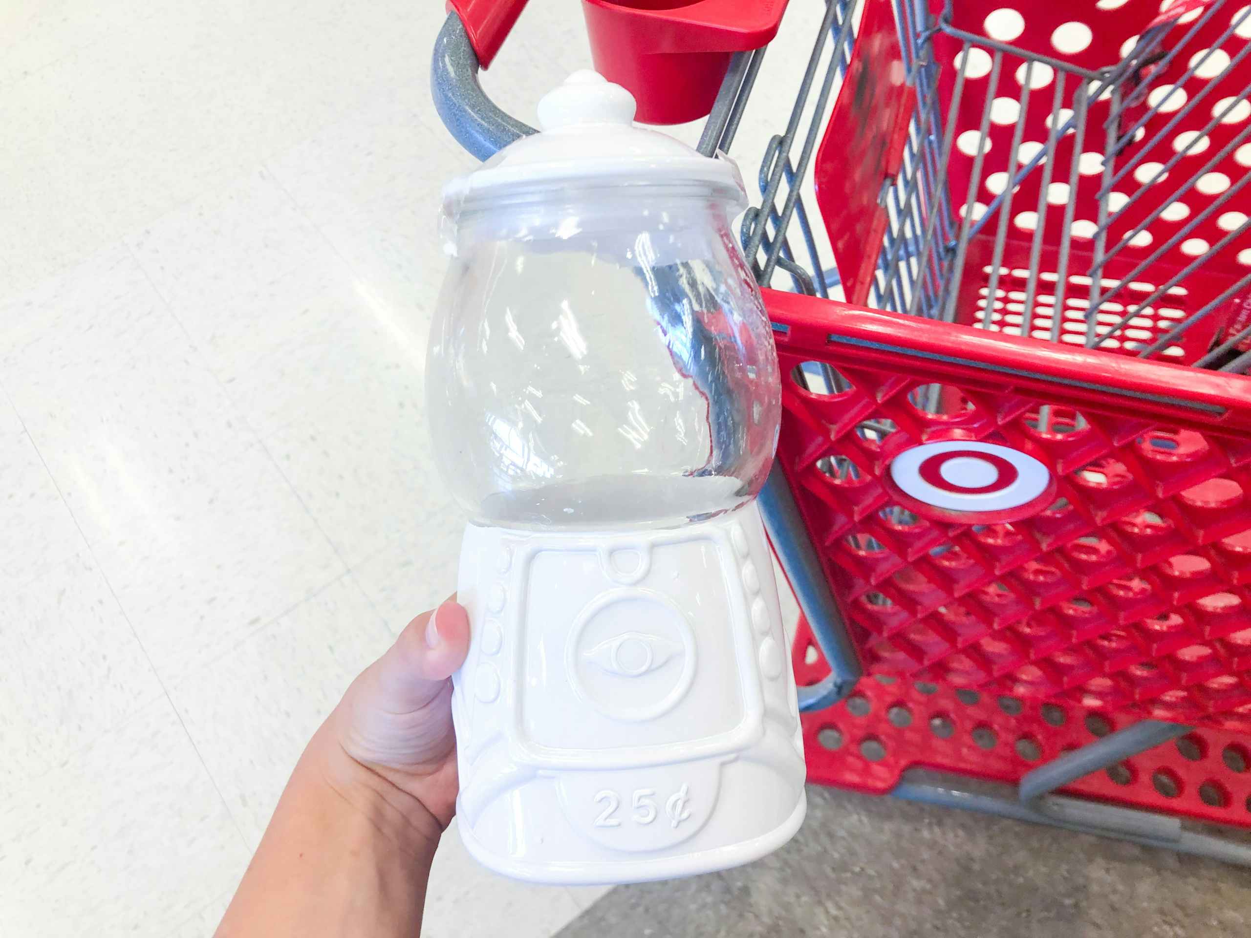 hand holding gum ball machine in front of Target shopping cart