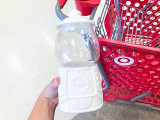 hand holding gum ball machine in front of Target shopping cart
