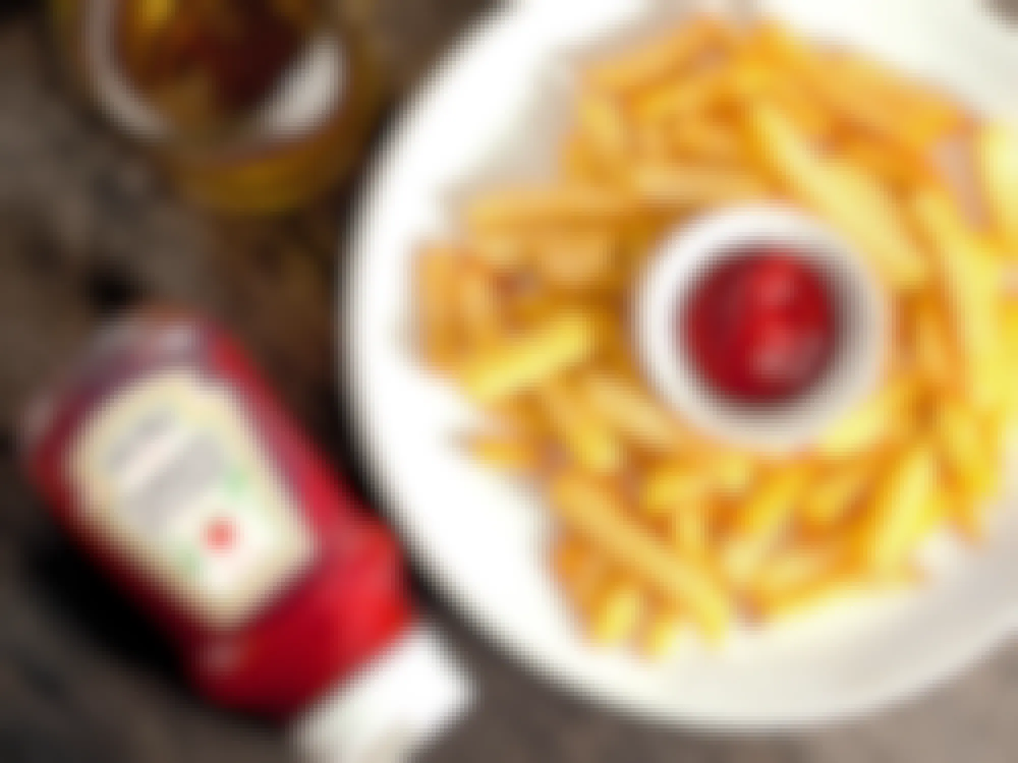 bottle of heinz ketchup and plate of french fries on table