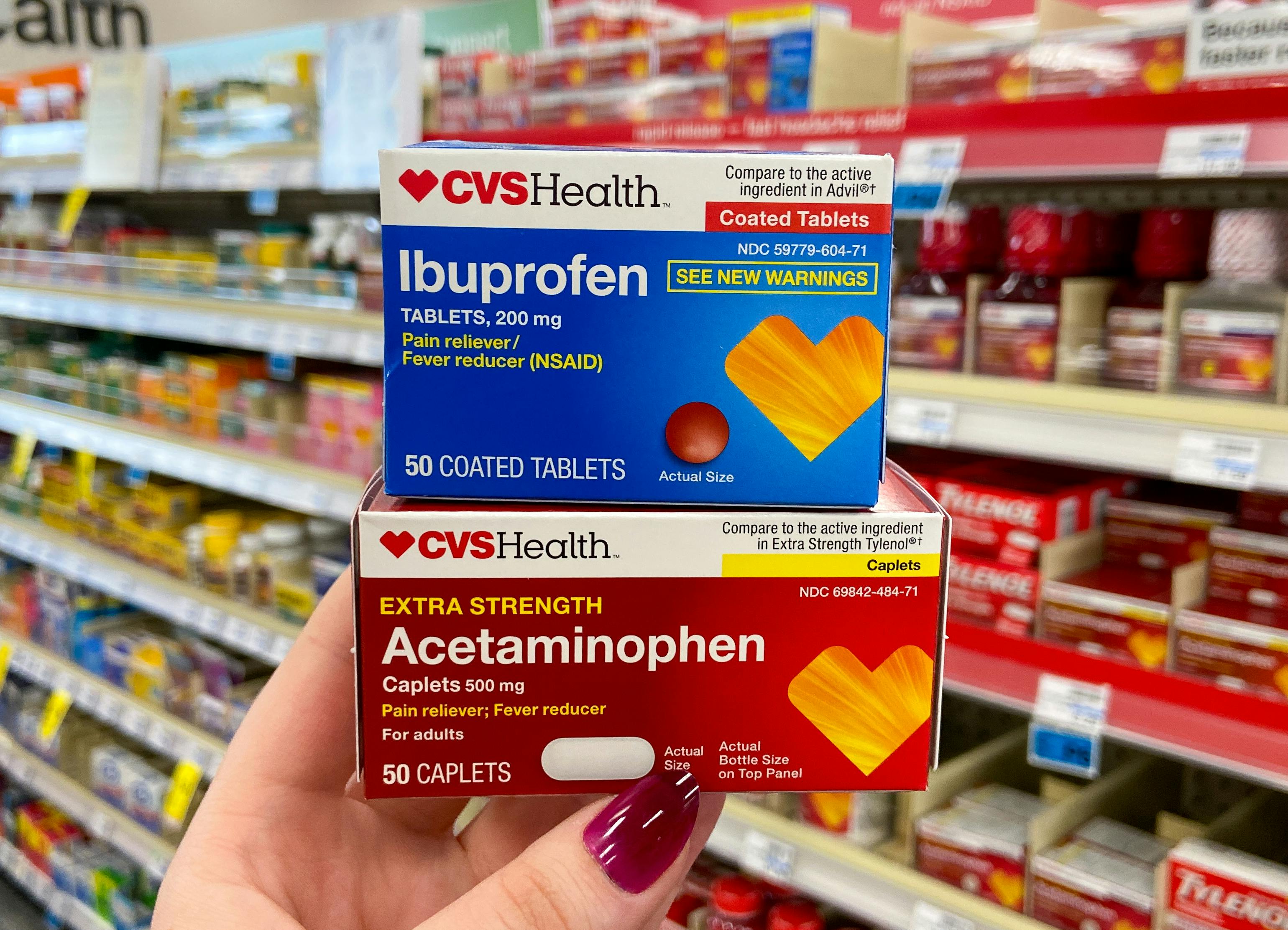 someone holding cvs health acetaminophen and ibuprofen