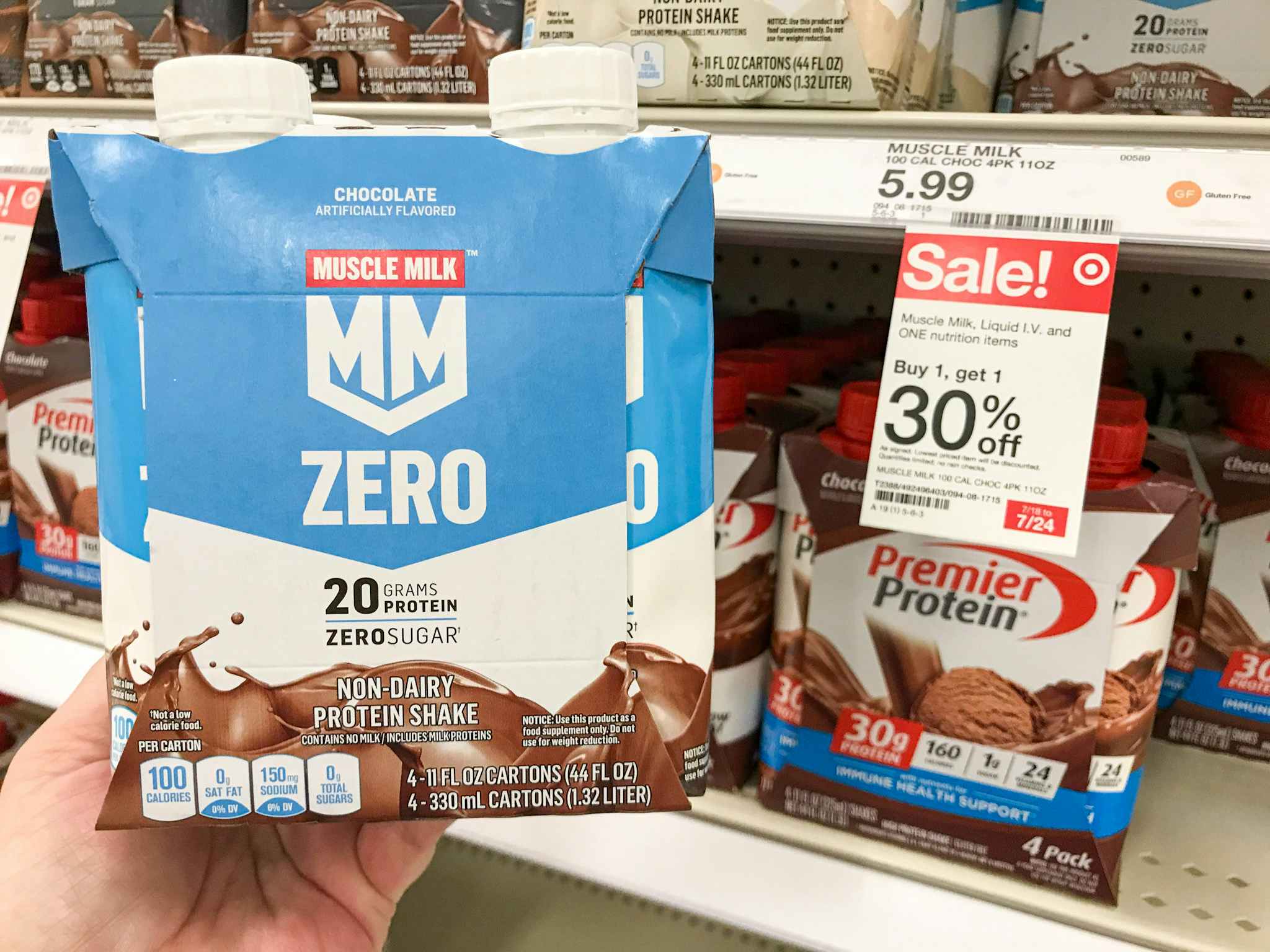 hand holding a 4-pack of muscle milk protein shakes at target