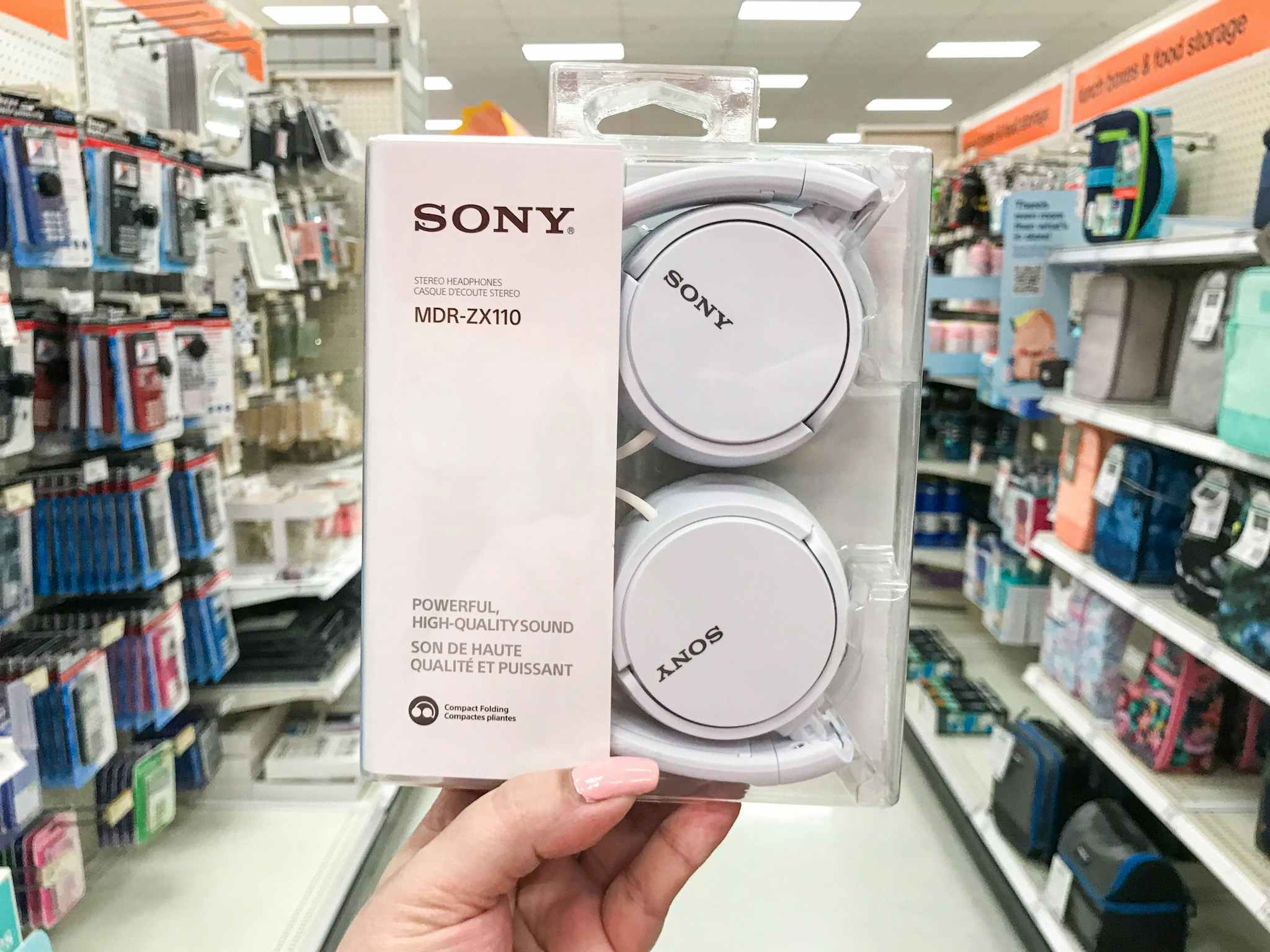 hand holding a white pair of sony headphones at target