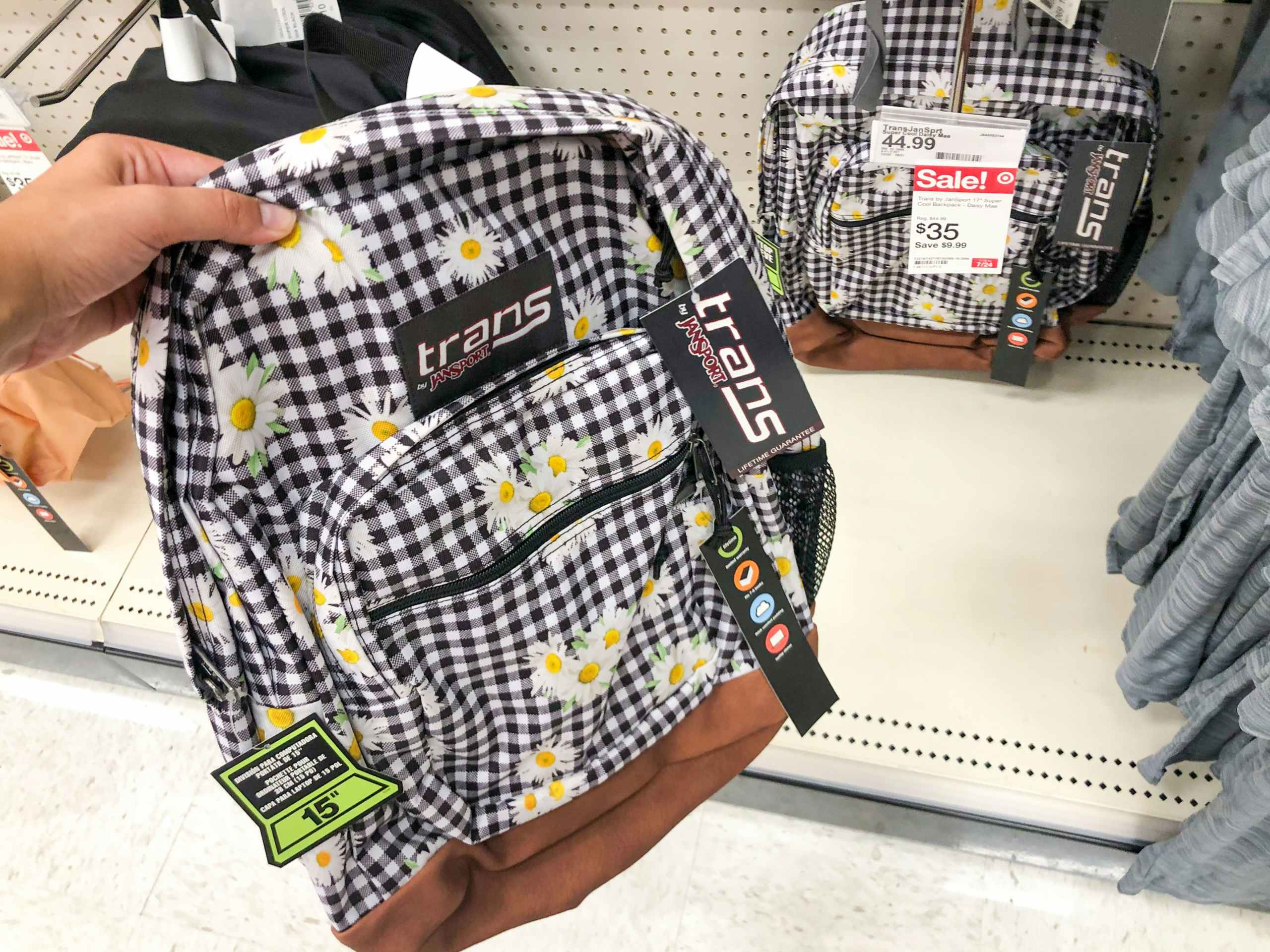 hand holding up backpack in front of backpack display at Target