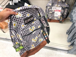 hand holding up backpack in front of backpack display at Target