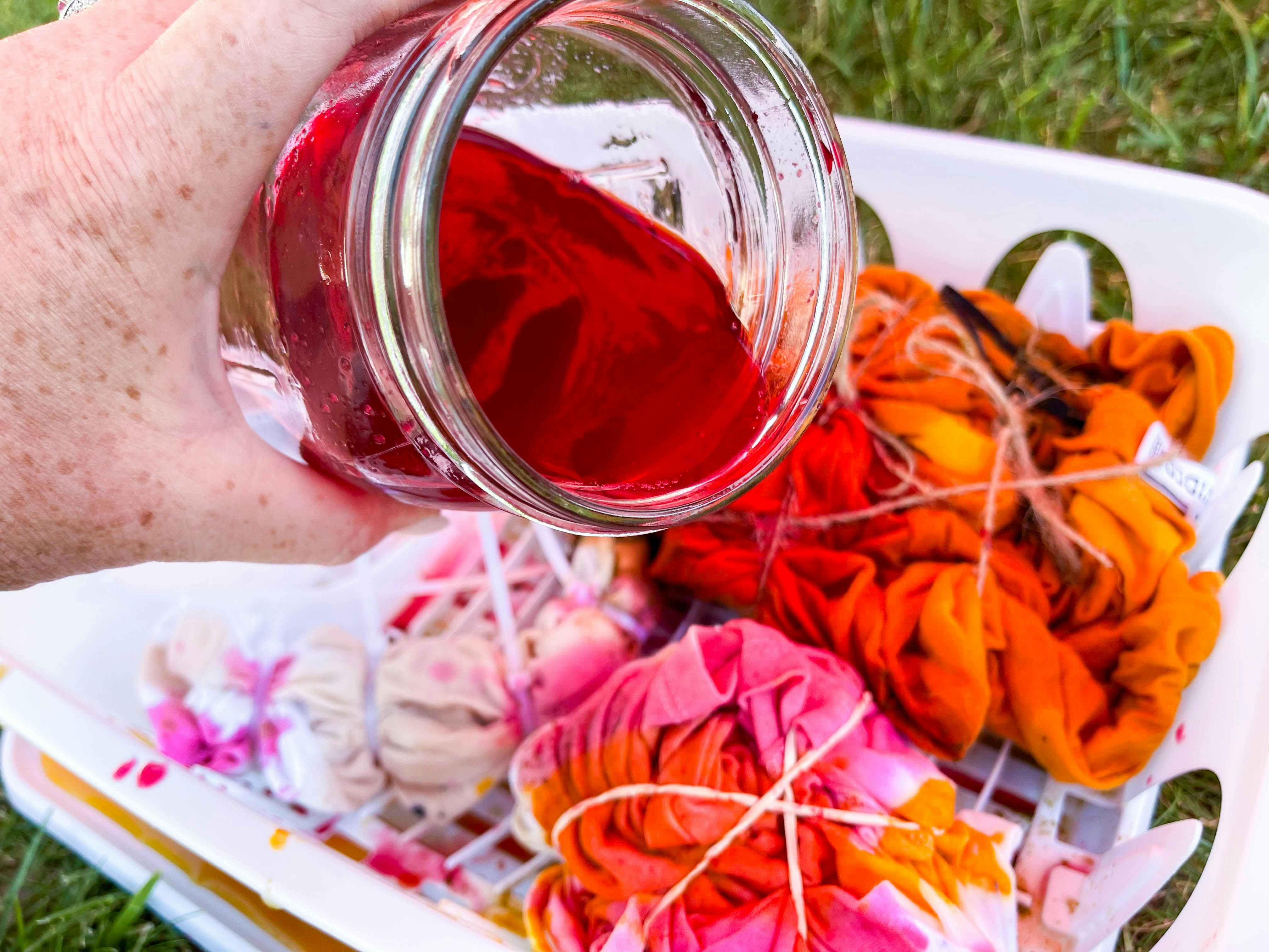 hand pouring beet juice on shirts