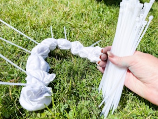 zip ties on shirt with hand holding zip ties