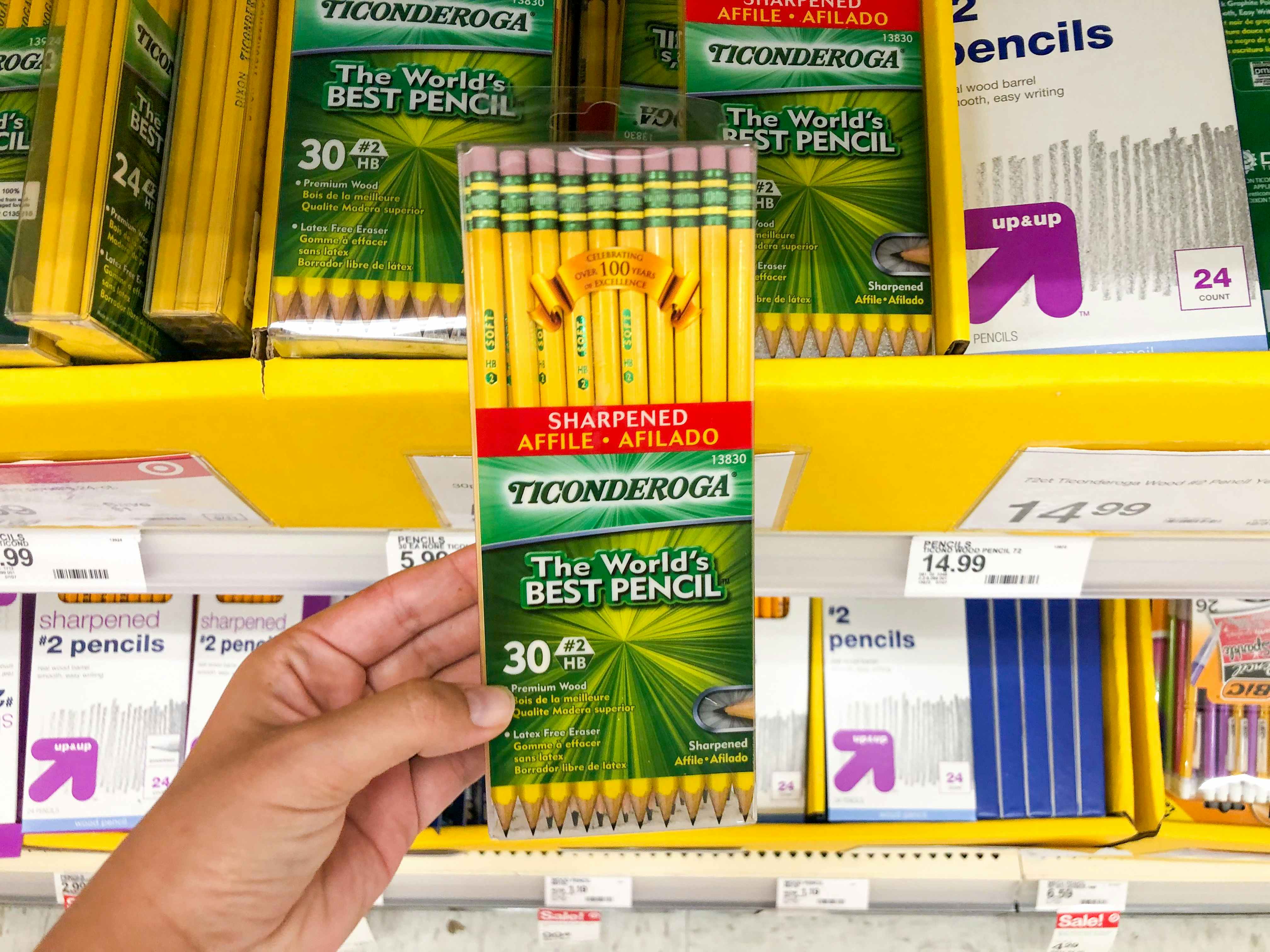 hand holding Ticonderoga pencils in front of school supply section at Target