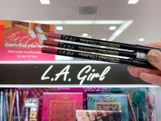 hand holding L.A. Girl lip liners in front of display