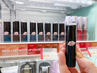 hand holding wet n wild lipstick in front of display
