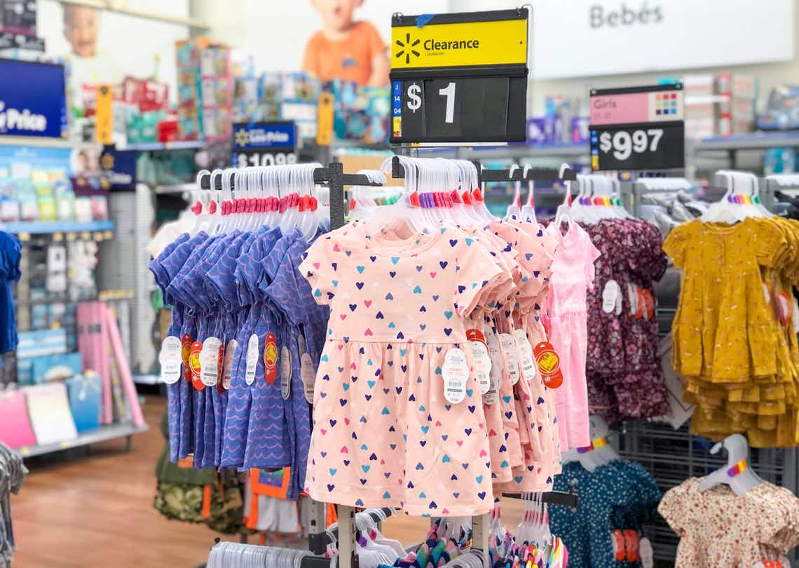 wonder nation baby dresses hanging on rack with $1 clearance sign above them
