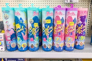 a bunch of barbie color reveal susprise doll tubes with clearance price tags on walmart shelf