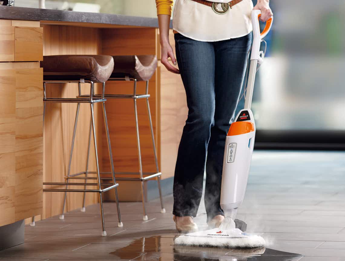 stock photo of woman using bissell powerfresh steam mop in a kitchen area