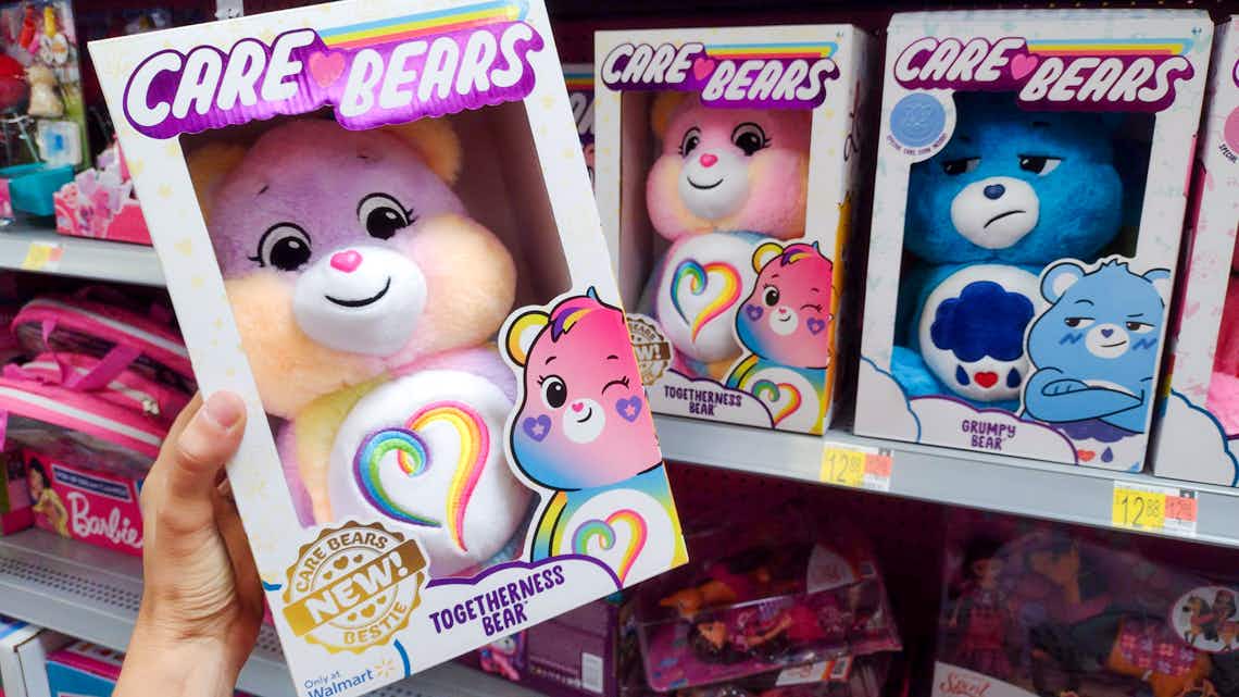 the new care bear togetherness bear held in front of other care bears on walmart shelf