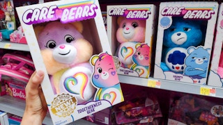 the new care bear togetherness bear held in front of other care bears on walmart shelf