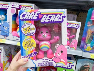 care bear cheer bear interactive toy held up in front of other care bear toys