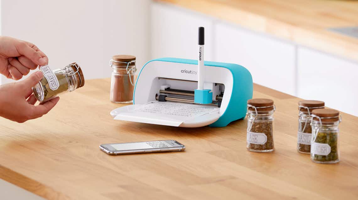 stock photo of cricut joy machine staged on counter with labels and spice jars