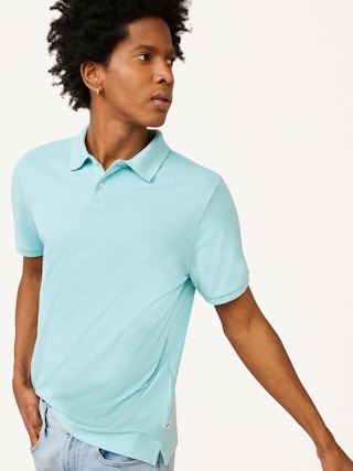 stock photo of man wearing free assembly aqua polo shirt against a white background