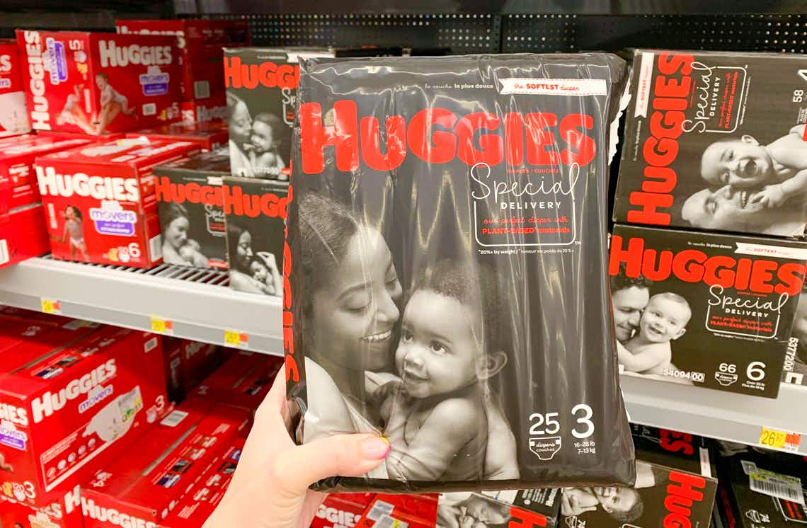 bag of huggies special delivery diapers held in front of other huggies diapers in walmart store