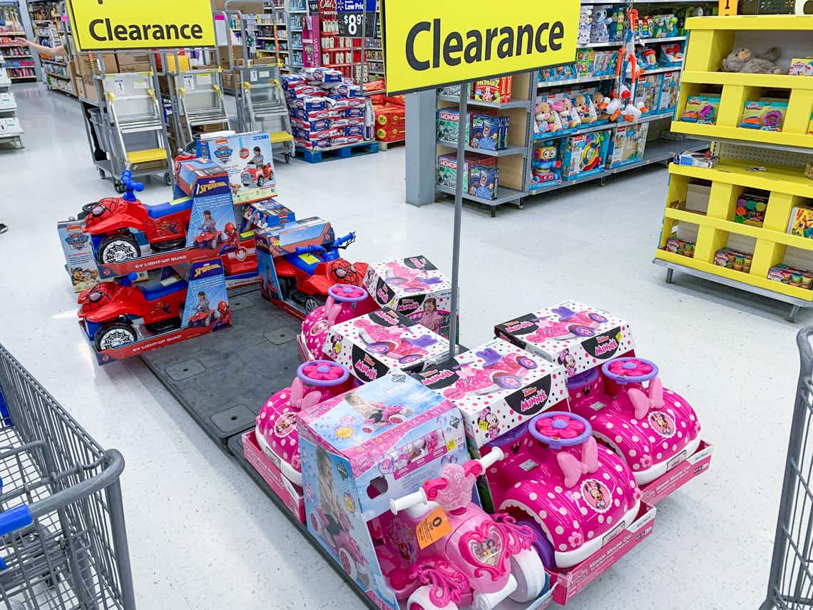 kids ride on toys on walmart pallet with large clearance sign above them