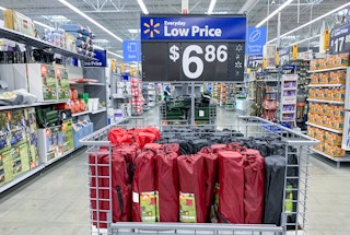ozark trail camping chairs in center aisle of walmart with price sign above the bin