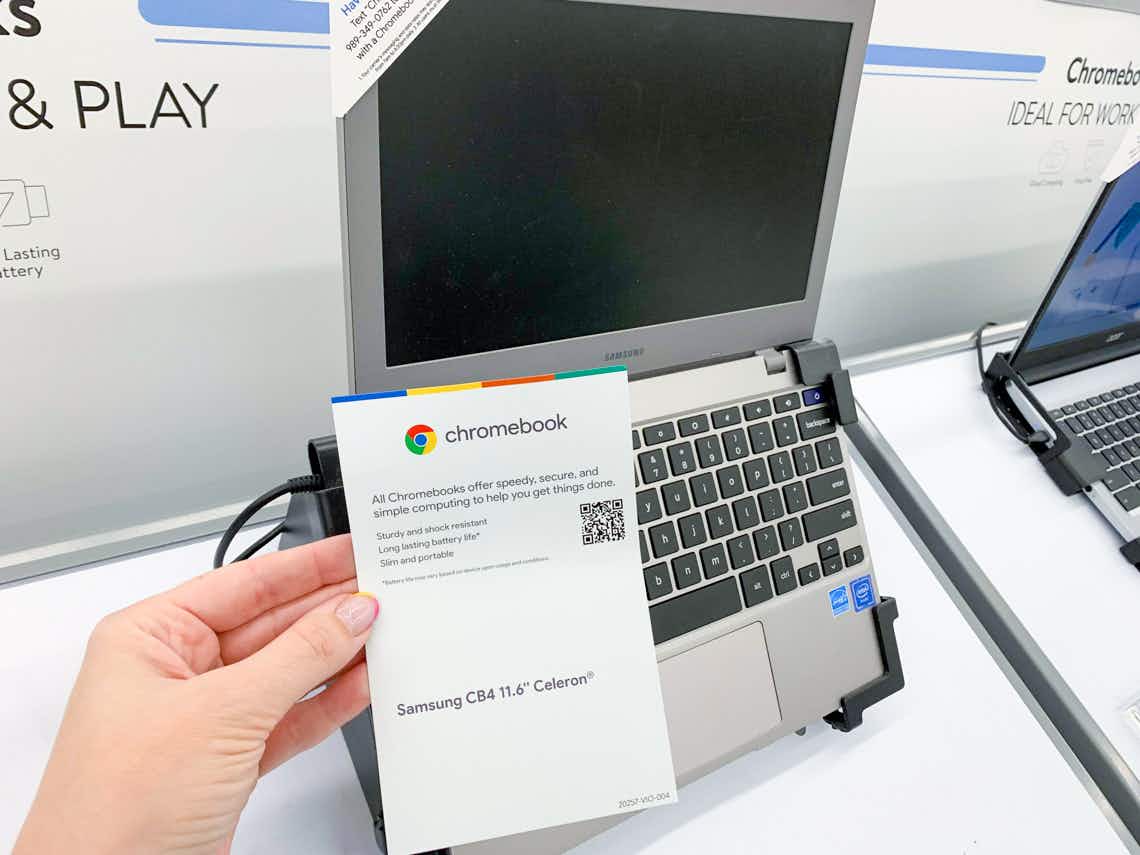 samsung cromebook on display in walmart electronics section with informational paper held in front