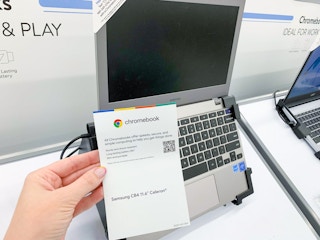 samsung cromebook on display in walmart electronics section with informational paper held in front
