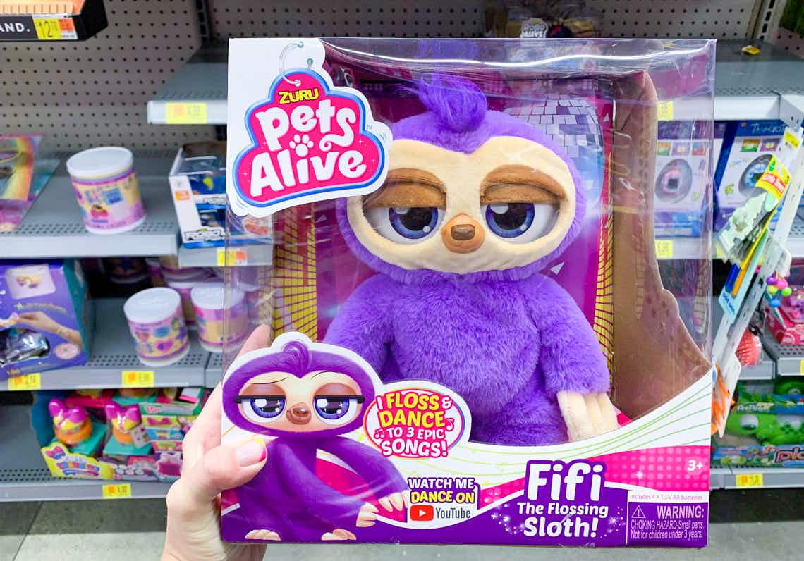 zuru pets alive fifi the flossing sloth robot toy held in front of other toys