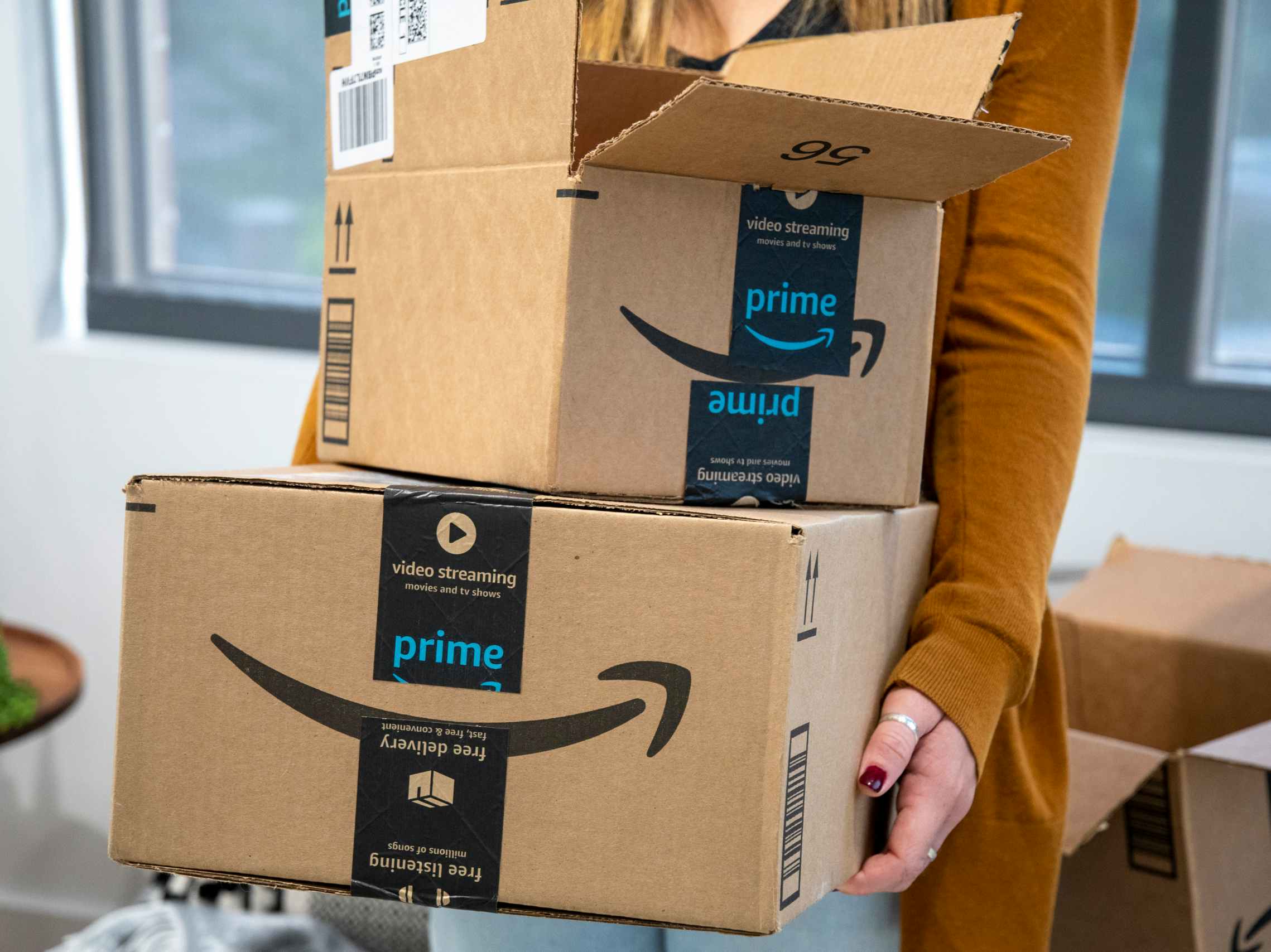 A woman holding two amazon boxes